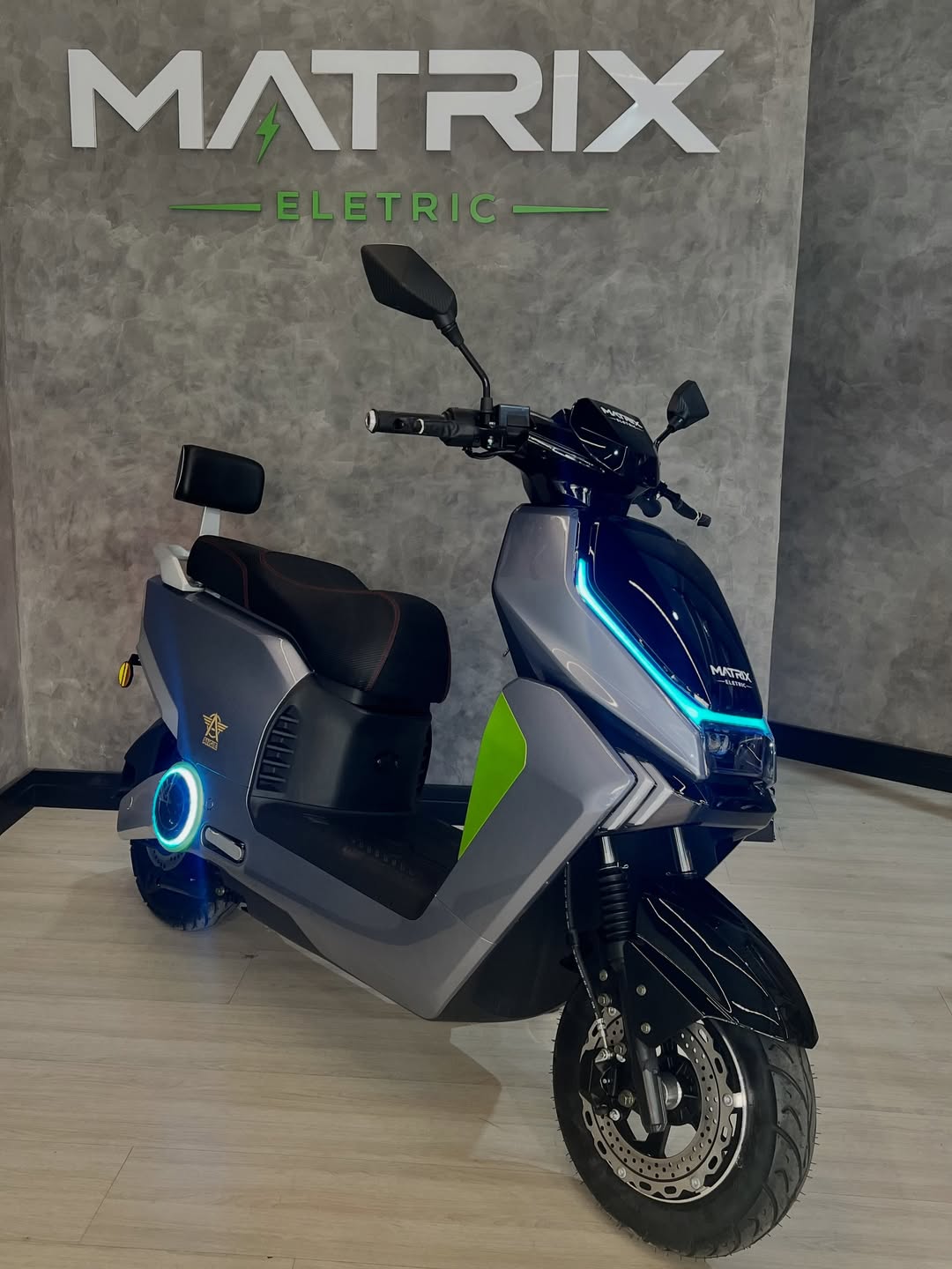 Scooter elétrica cinza com detalhes verdes na Matrix